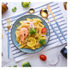 Black and Gold Stainless Steel Cutlery Set displayed with pasta dish on a stylish table setting.