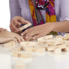 Players engaging with the Wooden Stacking Blocks Game, building with wooden blocks on a table.
