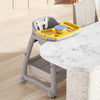Secure Adjustable High Chair with 5-Point Safety Harness positioned at a dining table, featuring a bright yellow tray.