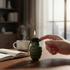 Compact Flame Ignition Novelty Lighter in grenade shape with flame, set on a wooden table next to a mug and open book.