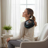 Woman using a Rolling Percussive Massage Device for relaxation and relief at home.