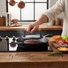 Round Cooking Press with Wooden Handle pressing a burger on a stovetop for perfect cooking.