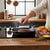 Round Cooking Press with Wooden Handle pressing a burger on a stovetop for perfect cooking.