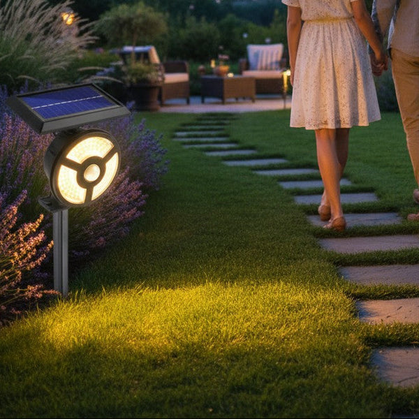 Solar Powered Motion Sensor LED Light illuminating garden path with couple walking at dusk.