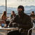 Man wearing a Balaclava Face Mask while holding a cup outdoors, enjoying the mountain view.