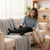 35 CM Plush Shark Soft Toy on the couch with a person enjoying its cuddly design.