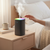 Mini Humidifier with RGB Light emitting mist on bedside table with colorful ambient lighting.