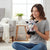 Woman holding a Small Sequin Cow Plush Toy, showcasing its colorful sequins in a cozy living room.