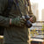 Person wearing Tactical-Style Fingerless Utility Gloves while holding a camera outdoors.