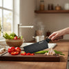 Japanese-Style Kitchen Cleaver Knife on a wooden cutting board with fresh vegetables being chopped.