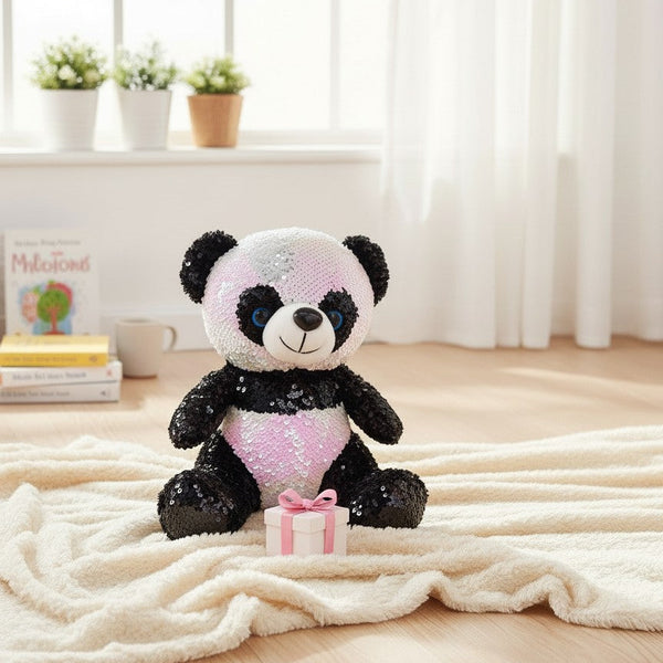 Sequin Panda Plush Toy sitting on a fluffy rug with a small gift box, showcasing its colorful sequined design.