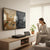 Woman enjoying a beverage while watching a 5-in-1 Digital Video Recorder connected to a large TV displaying video footage.