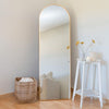 Arched Full Length Floor Mirror with Gold Frame leaning against a wall in a modern room setting.