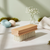 Wooden Laundry Shoe Brush with Stiff Bristles placed on a table with decorative items in the background.