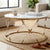 Round Marble Top Coffee Table with gold accents and clear legs in a cozy living room setting.